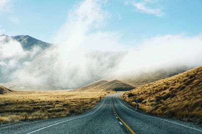 Panoramic view of country road by mountains against sky