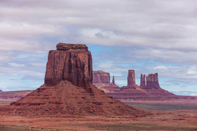 Rock formations on landscape against cloudy sky