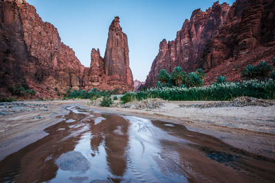 River flowing amdist rock mountains against sky