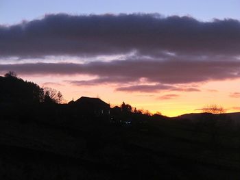 Scenic view of silhouette mountains against dramatic sky