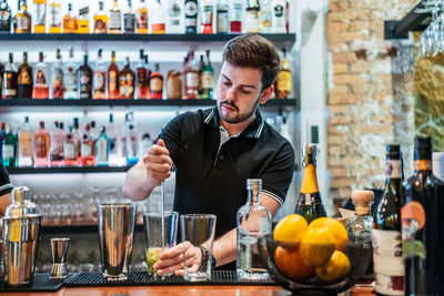 Full length of man standing by bottles