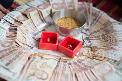 High angle view of jewelry and paper currencies in plate