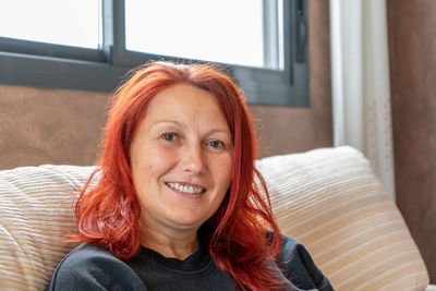 Portrait of smiling woman with redhead at home