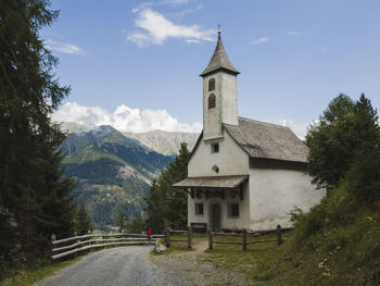 Church by road amidst buildings against sky