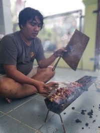Man preparing meat on barbecue grill