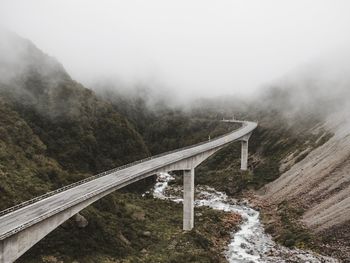 Bridge over mountains against sky during winter