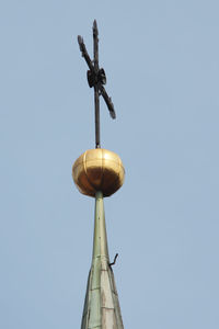 Low angle view of cross on street against clear blue sky