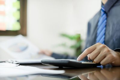 Midsection of businessman using mobile phone