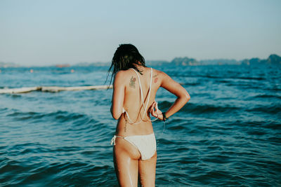 Rear view of woman standing against sea