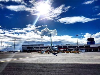 Cars on road against sky on sunny day