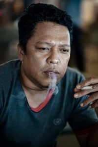 Close-up portrait of man smoking cigarette