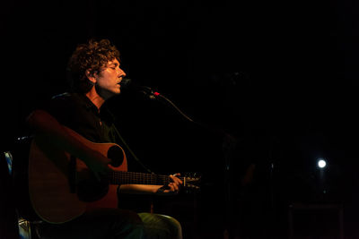 Man playing guitar at night