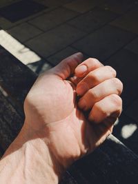 Cropped hand of person on bench