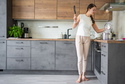 Low section of woman standing in kitchen