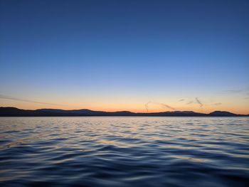 Scenic view of sea against clear sky during sunset