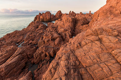 Rock formations on shore against sky