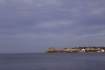 Scenic view of sea by buildings against sky