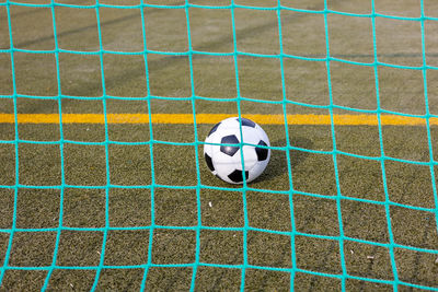Soccer ball inside the goal as seen from behind the net