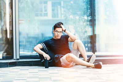 Portrait of young man sitting at window