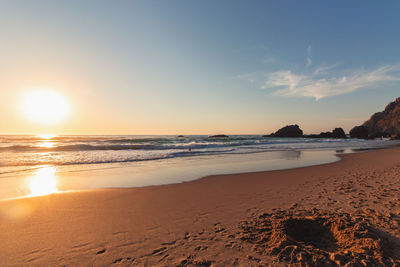 Scenic view of beach against sky during sunset