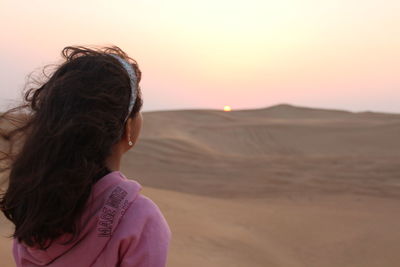 Girl looking at sunset at dubai's desert