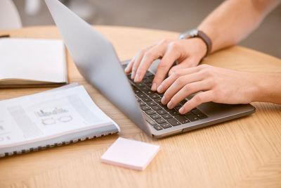 Midsection of woman using laptop on table