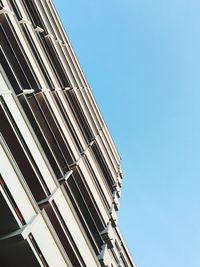 Low angle view of modern building against clear blue sky