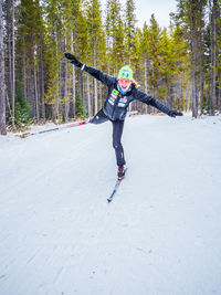 Full length of woman with arms raised in forest