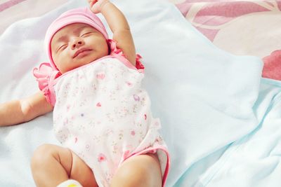 Cute baby girl sleeping on bed