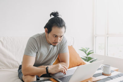 Young man using laptop at home