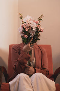 Midsection of man holding flower bouquet