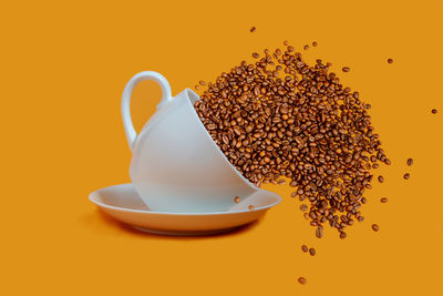 Close-up of coffee cup against orange background