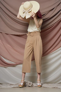 Low section of woman standing with umbrella