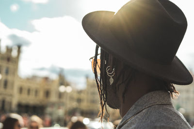 Close-up of young man standing in city against sky