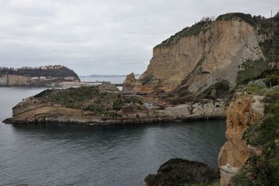 Rock formations by sea against sky