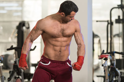 Muscular shirtless man standing in gym