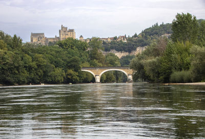 Arch bridge over river against sky