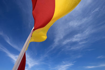 Low angle view of flag against blue sky