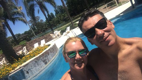 Portrait of couple wearing sunglasses in swimming pool