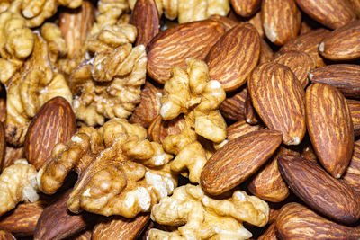 Peeled almond seeds and walnuts, close up background.