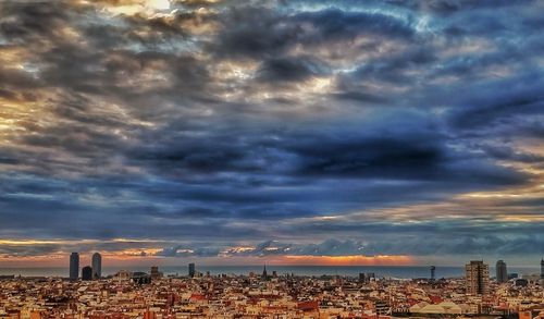 View of cityscape against cloudy sky