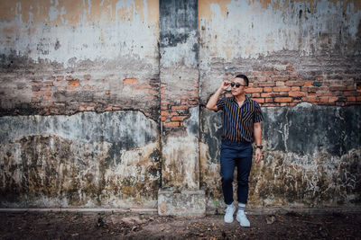 Man standing against wall in city