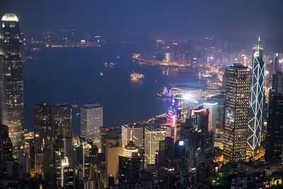 Illuminated cityscape against sky at night