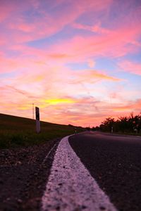 Empty road against sky during sunset