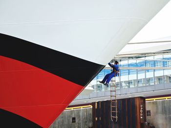 Man cleaning ship against building