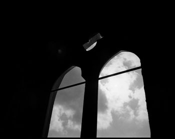 Low angle view of silhouette building against sky at night