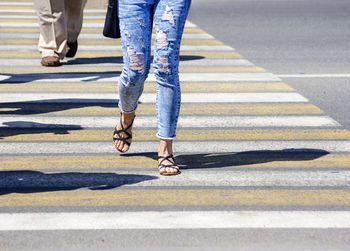 Low section of people crossing street in city