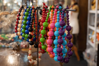 Group of plastic necklaces with colored balls hanging on a display stand.