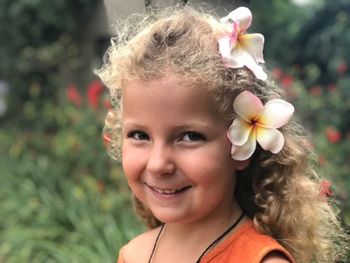 Close-up portrait of smiling girl wearing flowers