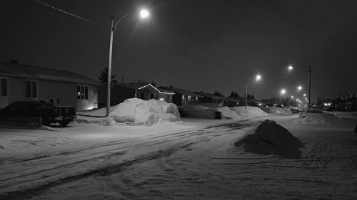 Snow covered road against sky at night